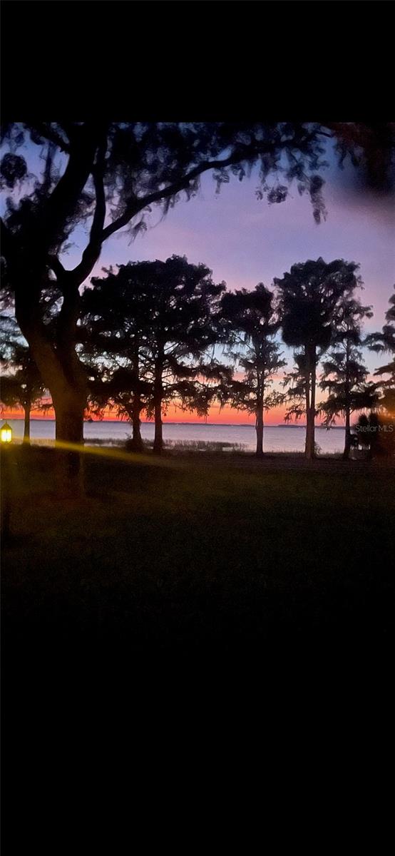 yard at dusk featuring a water view