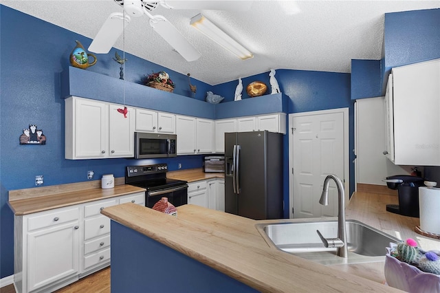 kitchen with wood counters, white cabinetry, black appliances, and a textured ceiling