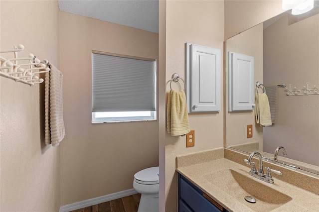 bathroom with vanity, hardwood / wood-style flooring, a textured ceiling, and toilet