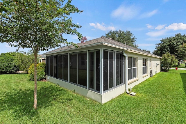 view of side of property with a yard and a sunroom