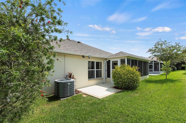 back of house featuring a sunroom, central AC unit, and a lawn