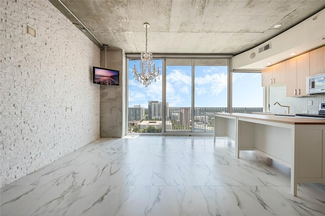 kitchen featuring pendant lighting, a wall of windows, and plenty of natural light