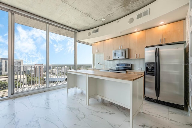 kitchen featuring tasteful backsplash, wooden counters, a wall of windows, stainless steel appliances, and light brown cabinets