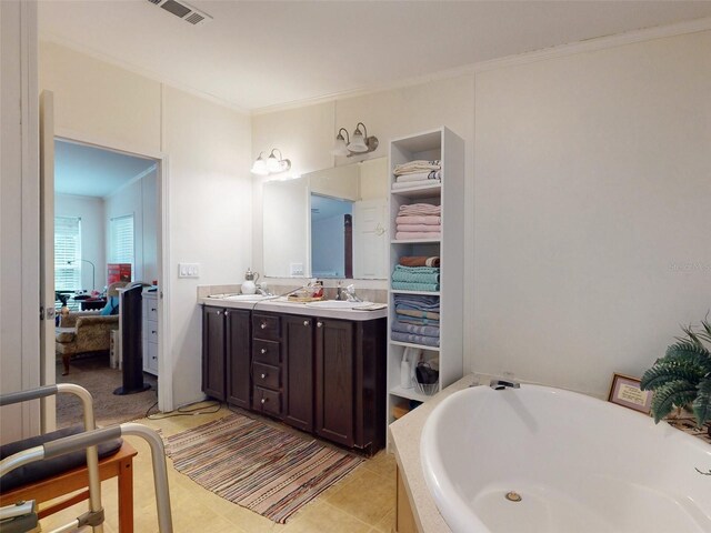 bathroom featuring a tub, tile patterned flooring, crown molding, and double vanity