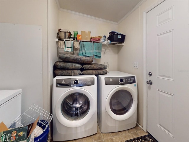 clothes washing area with ornamental molding, washer and dryer, and light tile patterned floors