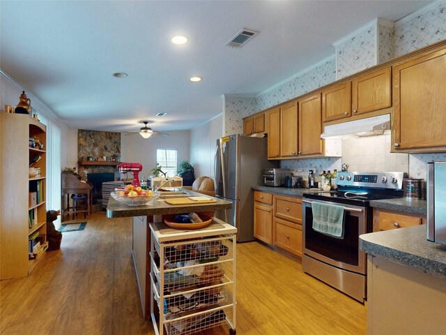 kitchen with decorative backsplash, appliances with stainless steel finishes, ceiling fan, and hardwood / wood-style floors