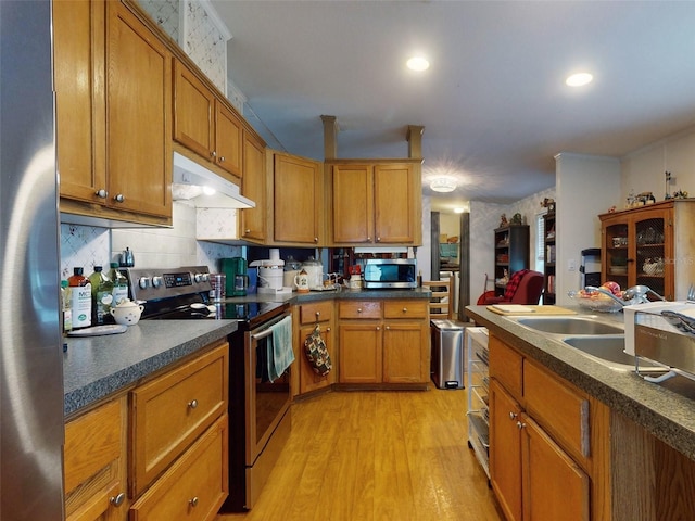 kitchen featuring sink, appliances with stainless steel finishes, decorative backsplash, and light wood-type flooring