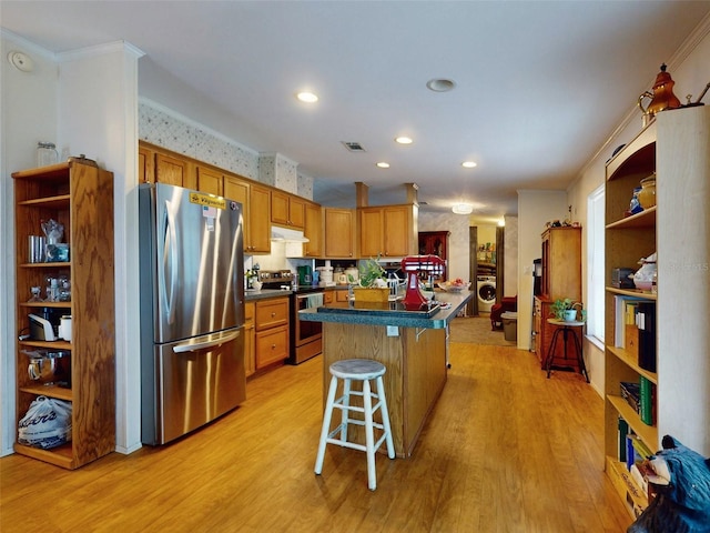 kitchen featuring light hardwood / wood-style flooring, stainless steel appliances, a kitchen island, crown molding, and a kitchen breakfast bar