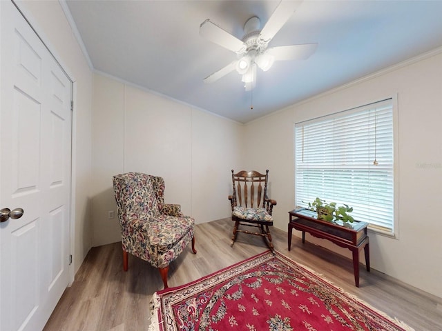 living area featuring ornamental molding, ceiling fan, and light hardwood / wood-style floors