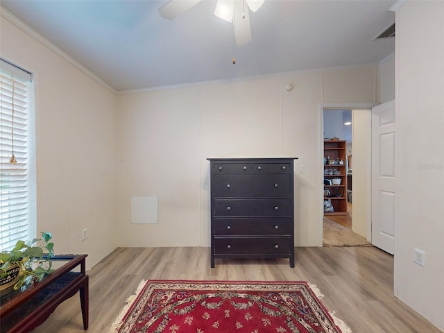 interior space with vaulted ceiling, crown molding, ceiling fan, and light hardwood / wood-style floors