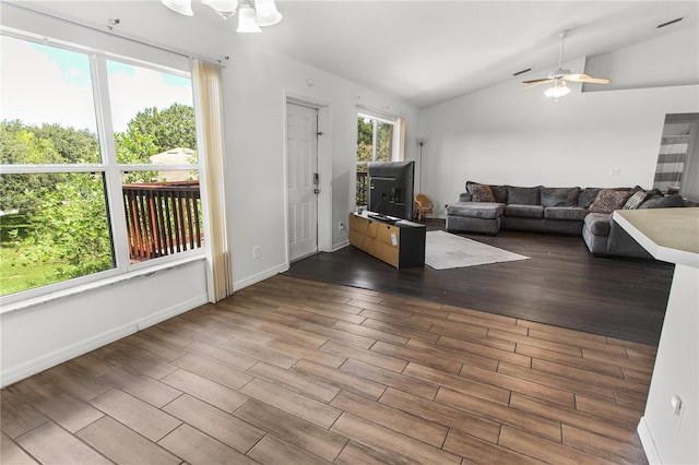 unfurnished living room featuring lofted ceiling and ceiling fan with notable chandelier