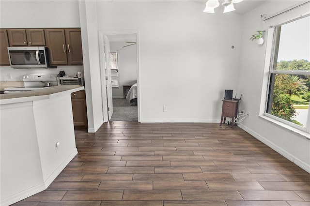 kitchen featuring white electric range and dark brown cabinets