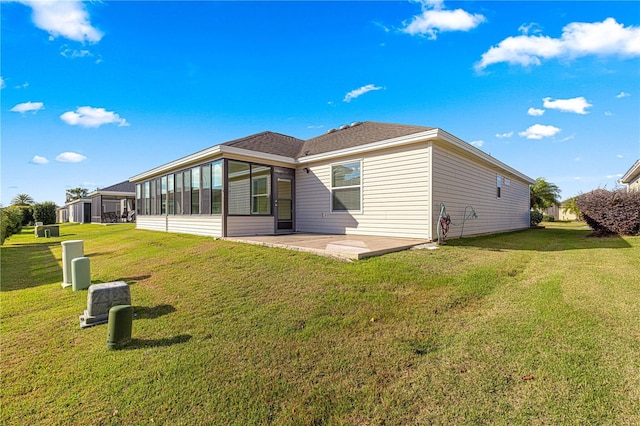 back of house featuring a yard, a patio area, and a sunroom