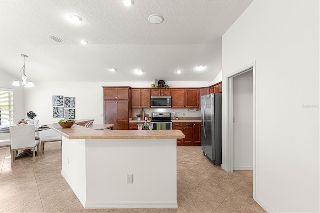 kitchen with decorative light fixtures, stainless steel appliances, a chandelier, and vaulted ceiling