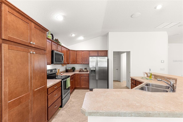 kitchen with kitchen peninsula, a textured ceiling, stainless steel appliances, sink, and lofted ceiling