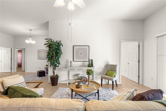 living room featuring ceiling fan with notable chandelier and light tile patterned floors