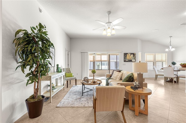 living room with light tile patterned floors, ceiling fan with notable chandelier, a textured ceiling, and vaulted ceiling