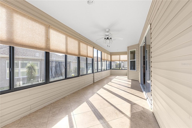 unfurnished sunroom featuring ceiling fan