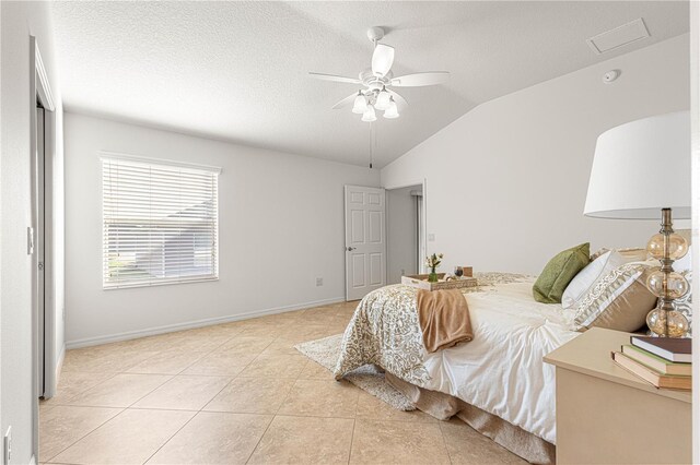 bedroom featuring ceiling fan, light tile patterned flooring, and vaulted ceiling