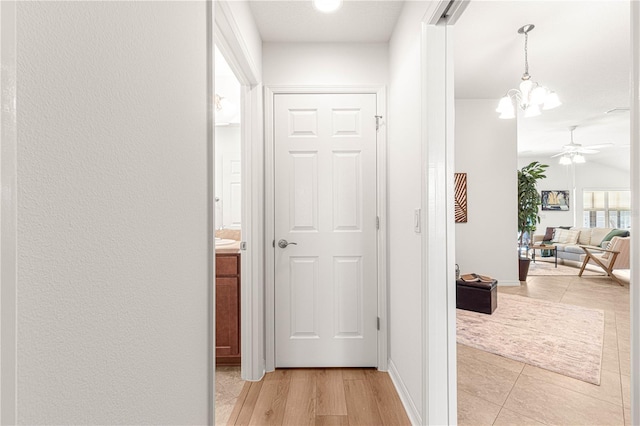 hallway featuring light hardwood / wood-style floors and a notable chandelier