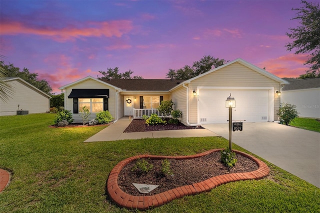 ranch-style house featuring a garage, a yard, cooling unit, and covered porch