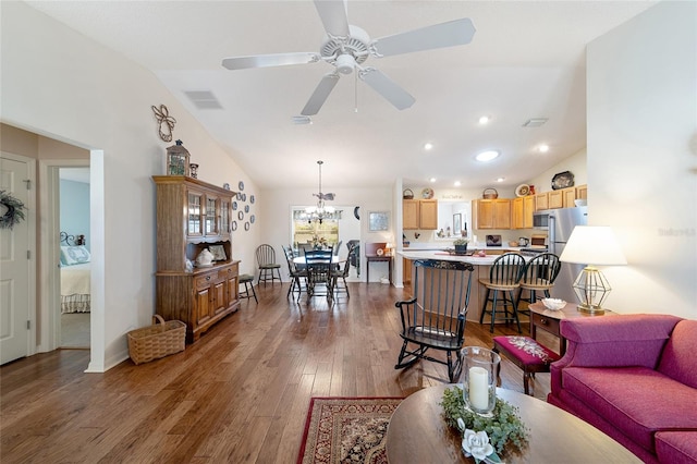 living room with vaulted ceiling, ceiling fan with notable chandelier, and hardwood / wood-style flooring