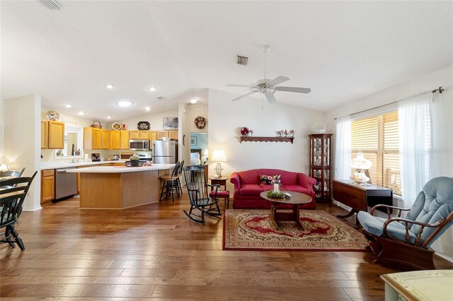 living room featuring ceiling fan, lofted ceiling, and wood-type flooring