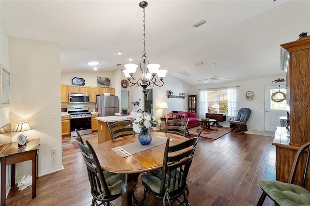 dining room featuring vaulted ceiling, ceiling fan with notable chandelier, and hardwood / wood-style floors