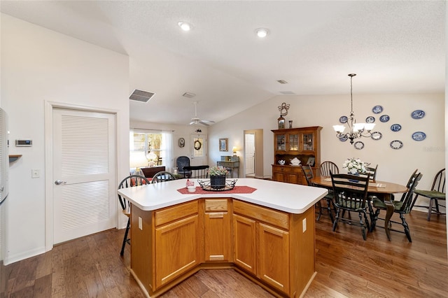 kitchen with a kitchen island, lofted ceiling, hardwood / wood-style flooring, and hanging light fixtures