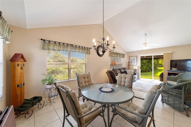 dining area with ceiling fan with notable chandelier, lofted ceiling, and light tile patterned floors