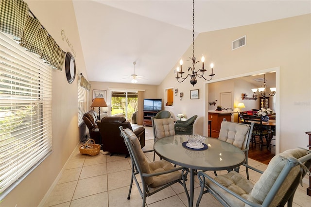 tiled dining room featuring high vaulted ceiling and ceiling fan with notable chandelier