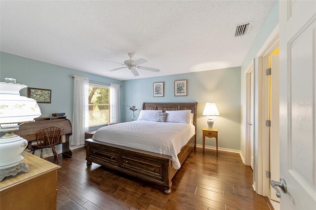 bedroom featuring ceiling fan, a textured ceiling, and dark hardwood / wood-style flooring