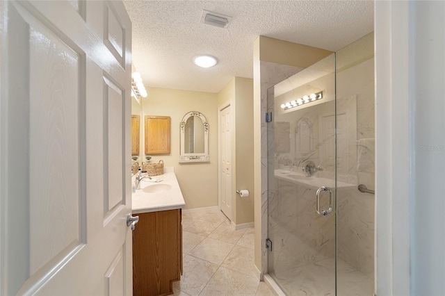 bathroom featuring tile patterned flooring, an enclosed shower, vanity, and a textured ceiling