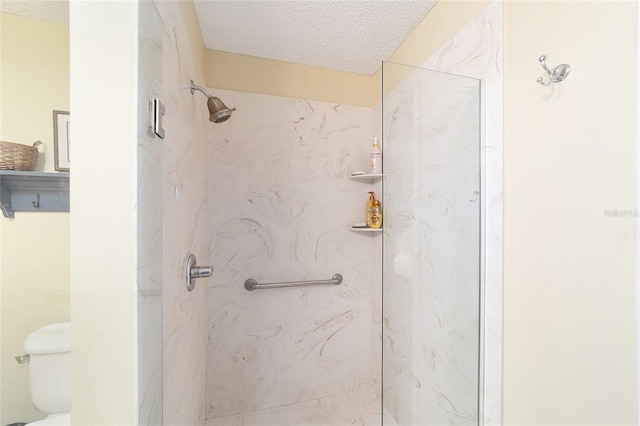 bathroom with an enclosed shower, a textured ceiling, and toilet