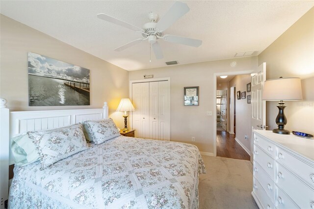 carpeted bedroom featuring ceiling fan and a closet