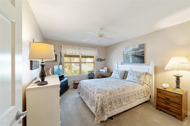 bedroom with ceiling fan, baseboards, and light colored carpet