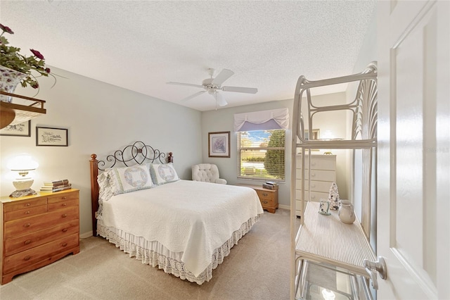 bedroom with a textured ceiling, carpet flooring, and ceiling fan