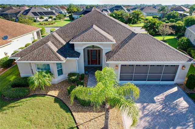 view of front of home featuring a garage, driveway, a shingled roof, and stucco siding