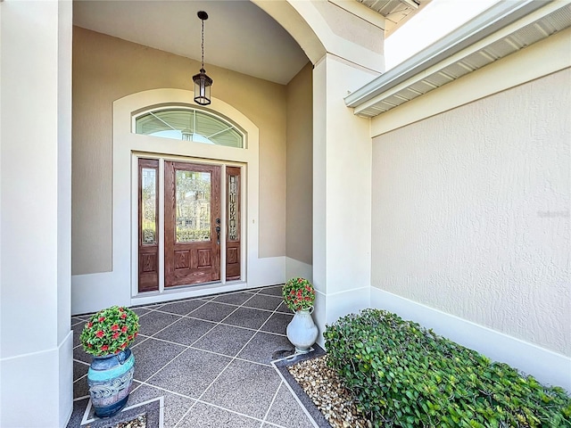 entrance to property featuring stucco siding