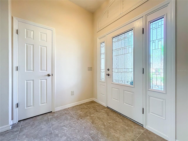 tiled entryway featuring a healthy amount of sunlight and baseboards