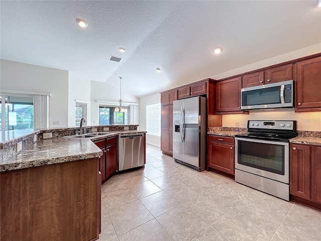 kitchen with visible vents, appliances with stainless steel finishes, decorative light fixtures, vaulted ceiling, and a sink