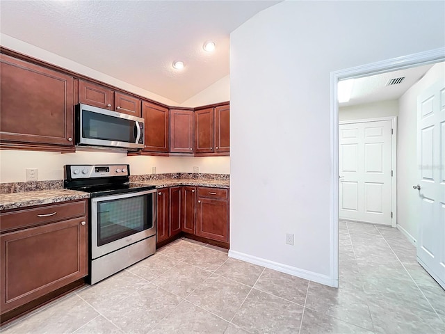 kitchen featuring appliances with stainless steel finishes, lofted ceiling, visible vents, and baseboards