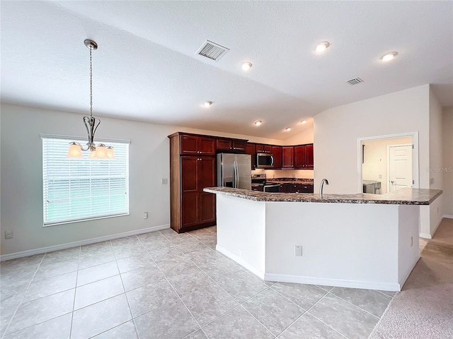 kitchen with appliances with stainless steel finishes, lofted ceiling, visible vents, and decorative light fixtures