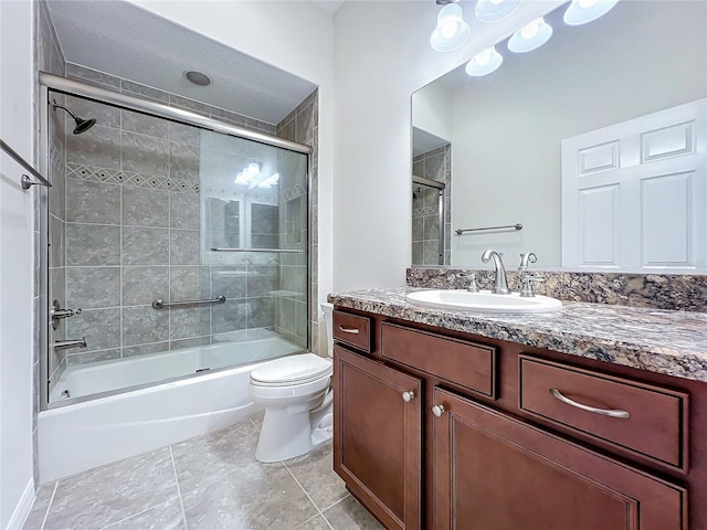 full bathroom with toilet, shower / bath combination with glass door, tile patterned flooring, and vanity