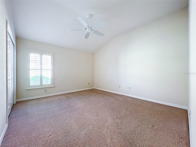 carpeted spare room with a ceiling fan, lofted ceiling, and baseboards