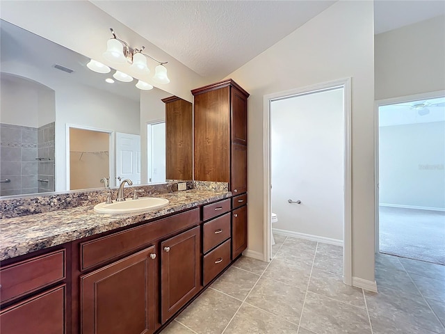 full bathroom featuring visible vents, toilet, vaulted ceiling, a textured ceiling, and vanity