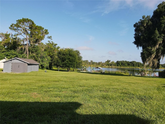 view of yard featuring a water view and an outbuilding