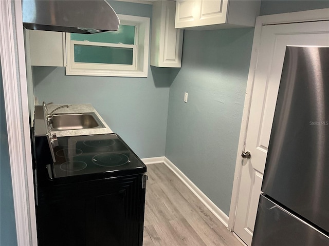 kitchen with stainless steel fridge, light hardwood / wood-style flooring, extractor fan, white cabinetry, and black range with electric cooktop