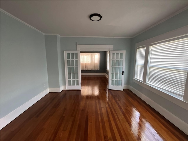 empty room featuring ornamental molding, dark hardwood / wood-style floors, and french doors