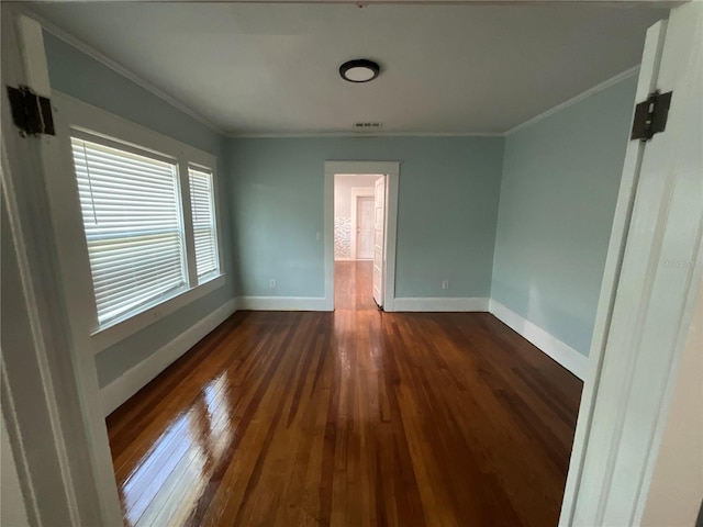 spare room with crown molding and dark hardwood / wood-style floors